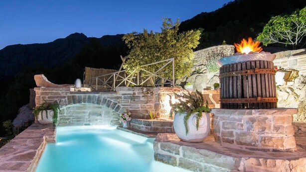 A stone hot tub with a wooden deck and a fire feature. - The Hidden Treasure Village, 7-Bedroom Luxury Holiday Resort with children playground, private Pool and Private Parking, SEA VIEW (Orebic)