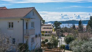 A coastal residential area with houses, a clear sky, and a view of the sea. - Charming Studio Apartment with Sea View (Orebic)