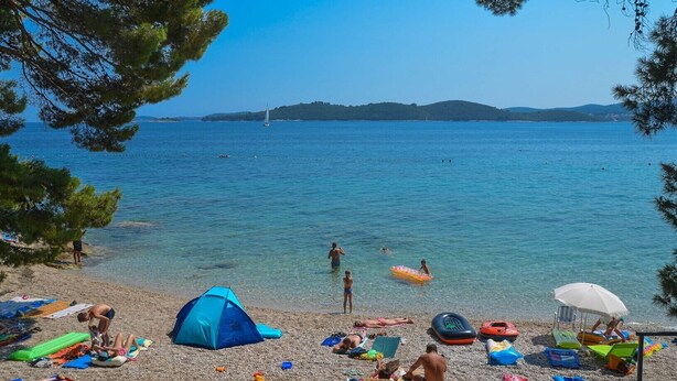 A beach with clear water, people swimming, and a tent. - Charming Studio Apartment with Sea View (Orebic)
