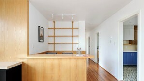 A modern kitchen with wooden cabinets, a built-in island with seating, and a patterned floor.