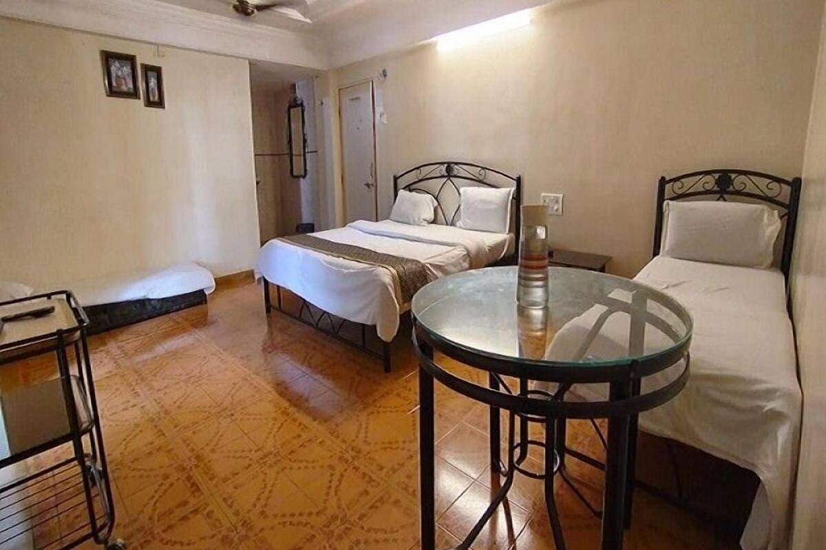 Een hotelkamer met een bed, een klein rond tafeltje, een kledingkast en een plafondventilator.