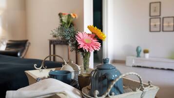 Ein Tisch mit einem Teekessel, Tassen und einer Vase mit Blumen.