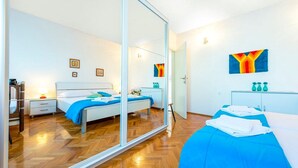 A modern hotel room with a large mirror, a bed with blue bedding, a bedside table with a lamp, and a small desk with a chair. - Great Holiday Home very close to the sea and main beach Trstenica (Orebic)