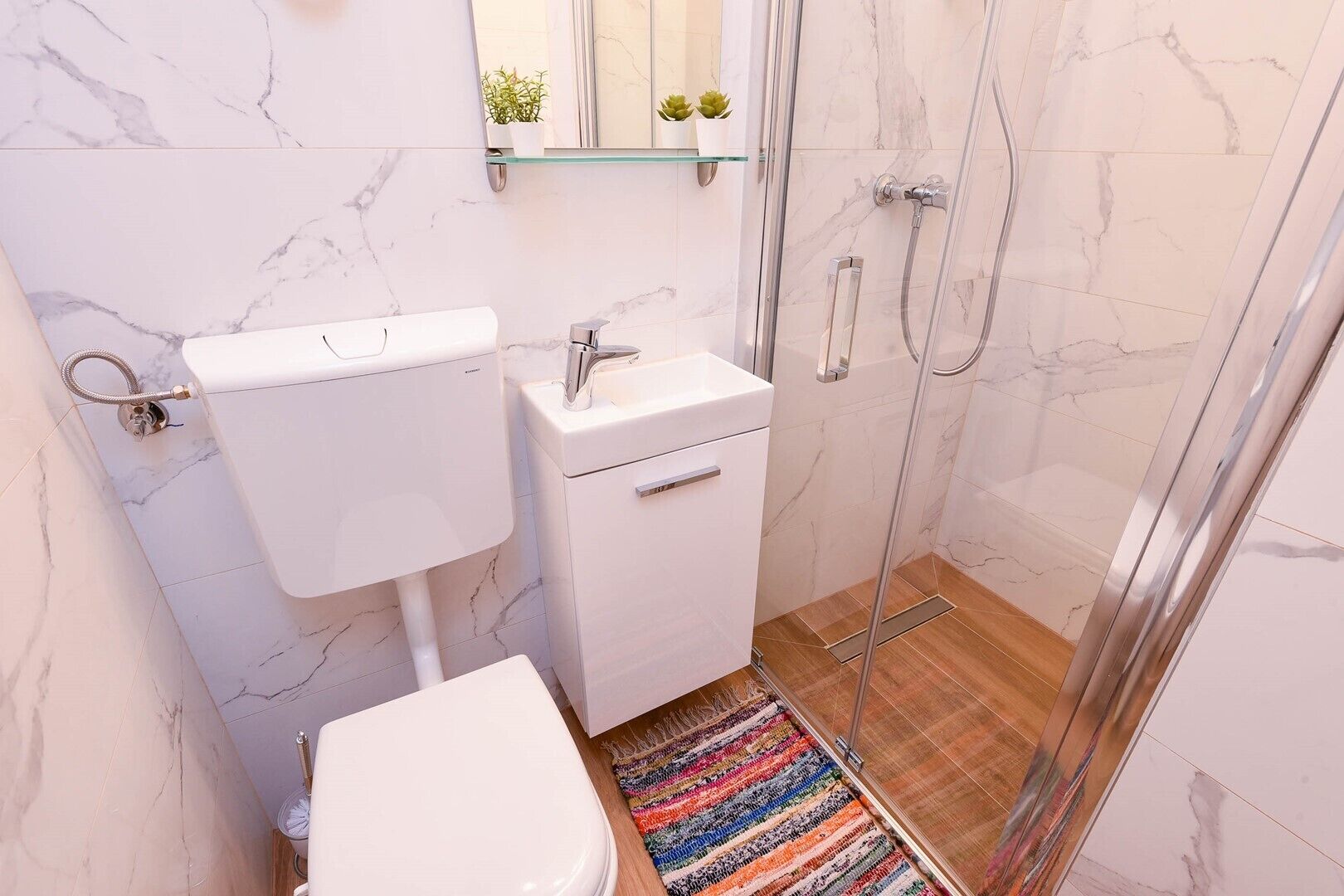 Un baño pequeño con inodoro, lavabo y ducha.