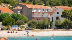 A coastal hotel with multiple buildings, a sandy beach, and clear blue waters. - Charming Studio Apartment Near the Sea (Orebic)
