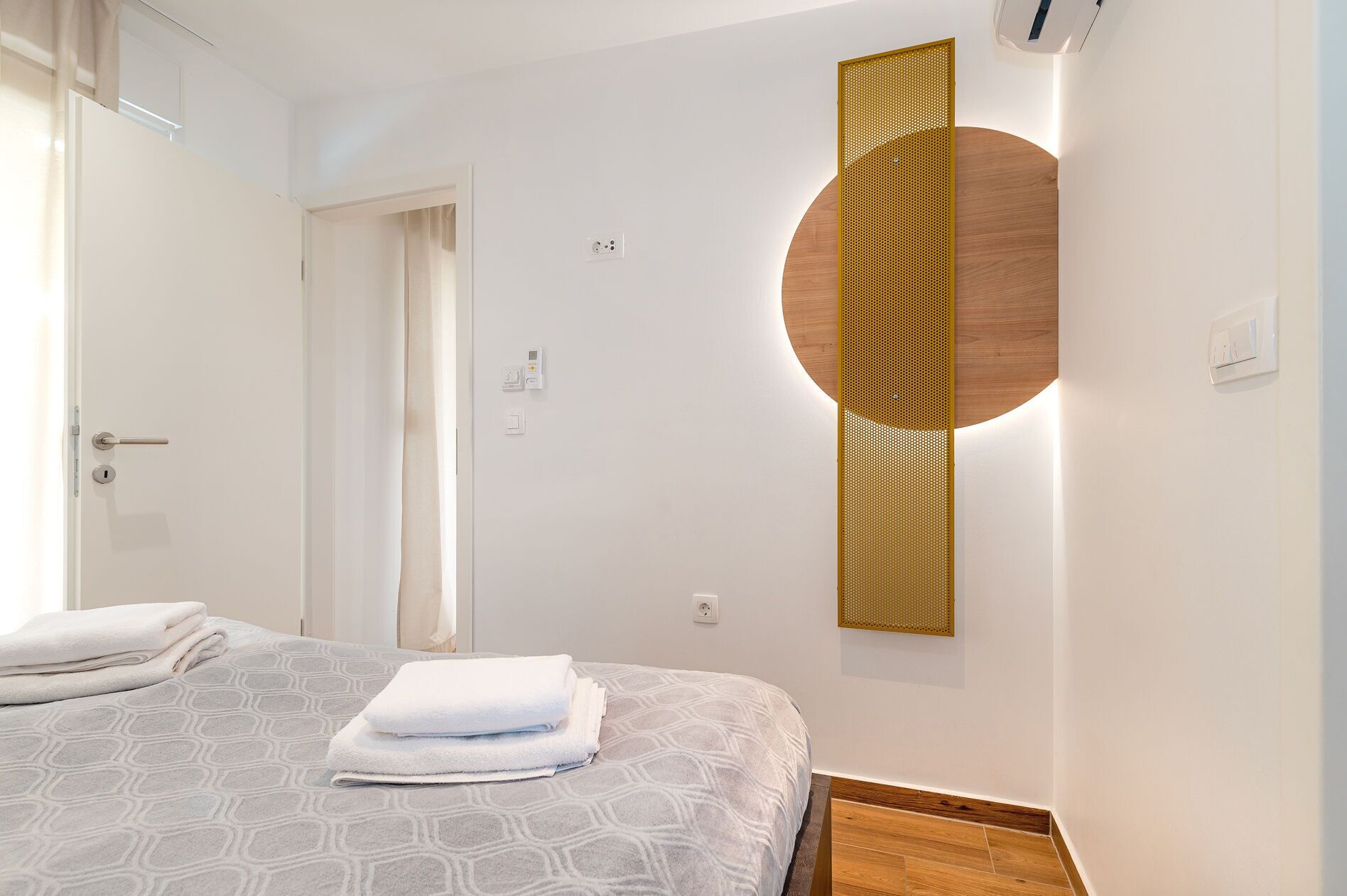 Ein Hotelzimmer mit einem Bett, einer Wandleuchte und einer Tür.