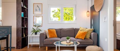 A modern living room with a sofa, coffee table, and a bookshelf.