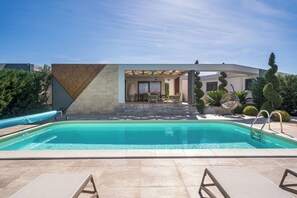 A swimming pool with a pergola, lounge chairs, and a patio area. - Villa Royal Green Two (Nin)