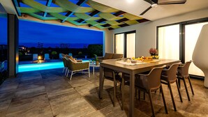An outdoor patio with a pool, dining table, and chairs. - Villa Royal Green Two (Nin)