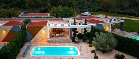 Une villa moderne dotée d’une piscine, d’un espace extérieur aménagé et offrant une vue sur le paysage environnant.