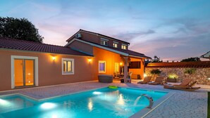 A swimming pool with lounge chairs and a covered patio area. - Villa Nika (Konjevrate)