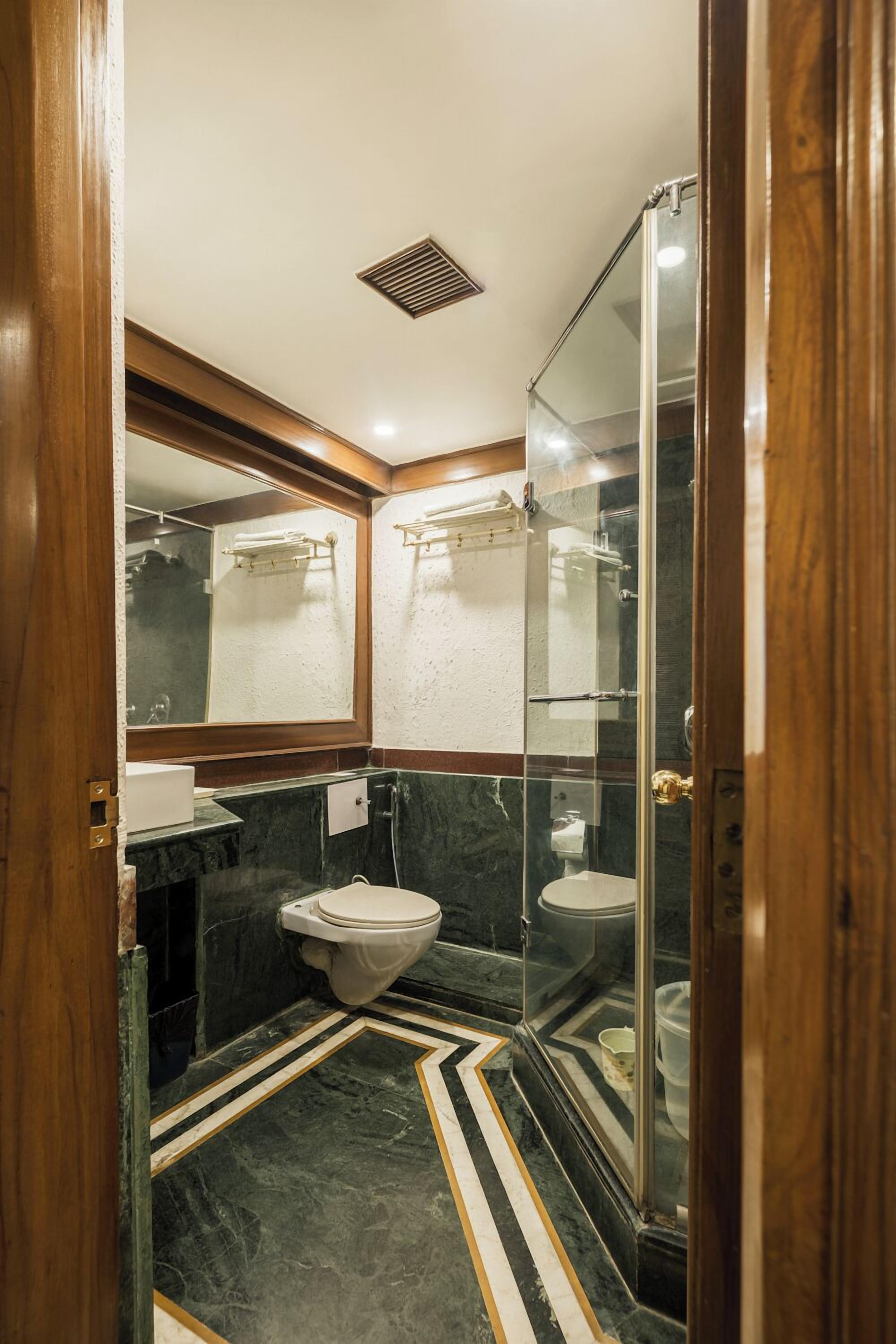 A compact bathroom with a toilet, sink, and shower area.
