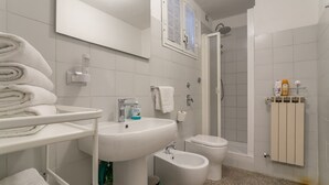 A modern bathroom with a sink, bidet, toilet, and shower. - Spacious Studio in via Sammartini 33 (Milan)