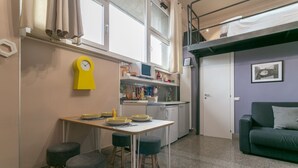 A compact living space with a kitchen, dining area, and a sofa. - Spacious Studio in via Sammartini 33 (Milan)