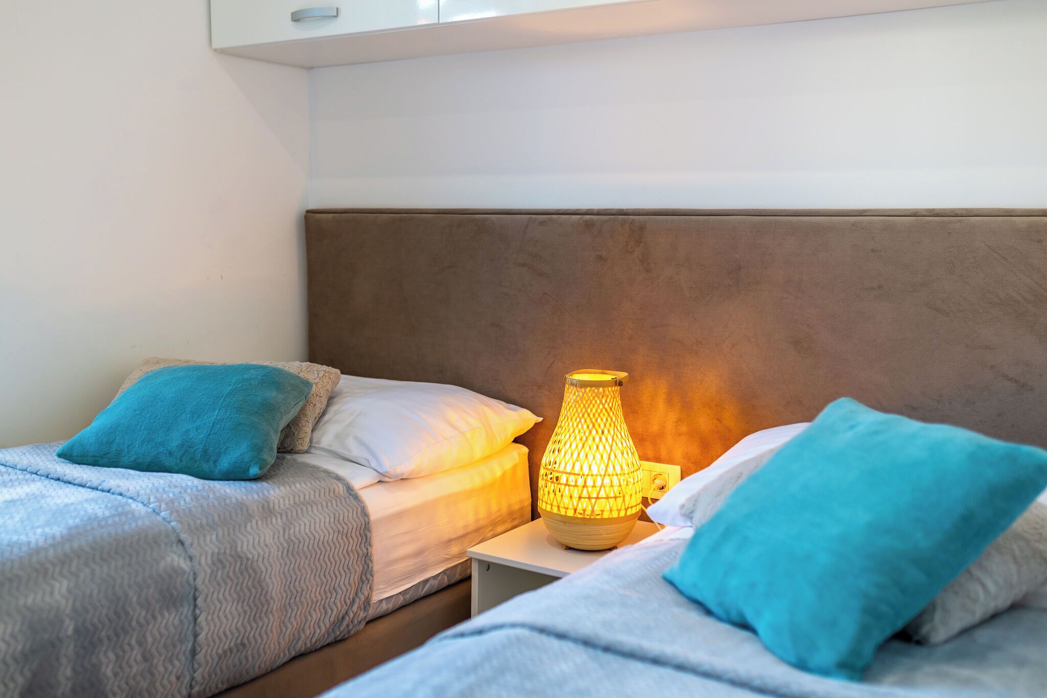 Ein Schlafzimmer mit zwei Betten, einem Nachttisch und einem Wandregal.