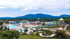 A water park with multiple slides and pools, surrounded by mountains.