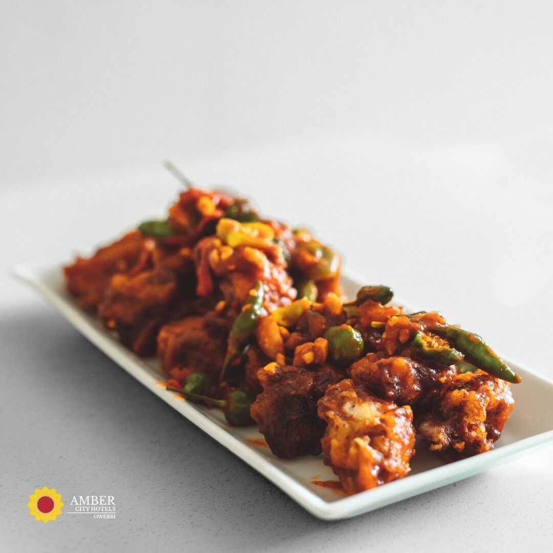 A dish of fried chicken with vegetables on a white plate.
