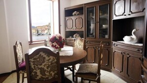 A dining area with a round table, chairs, and a view of a cityscape through a window. - Apartment Il Veliero with Amazing Sea View (Portoferraio)