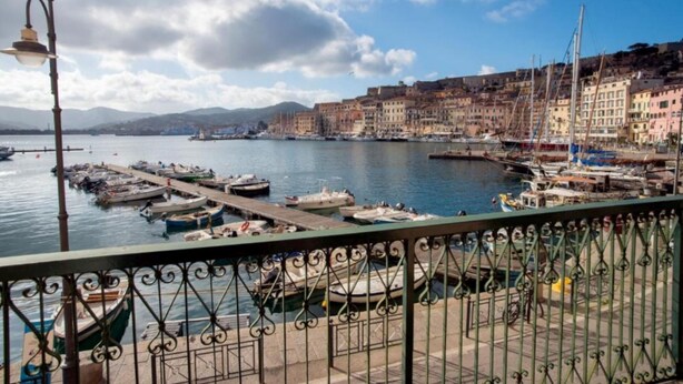A coastal town with a marina, boats docked, and buildings along the waterfront. - Apartment Il Veliero with Amazing Sea View (Portoferraio)