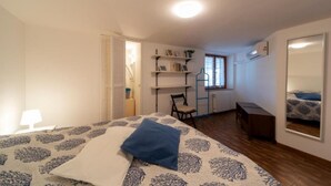 Un dormitorio con una cama, una silla, un escritorio y una estantería.