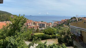 A coastal town with buildings, greenery, and a view of the sea. - Three-room apartment Villa Paola in Rio Marina (Rio Marina)
