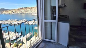 A balcony with a view of a marina and buildings across the water.
