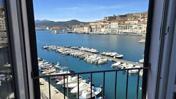 Una marina con barche ormeggiate, una vista limpida sull'acqua e edifici sullo sfondo.