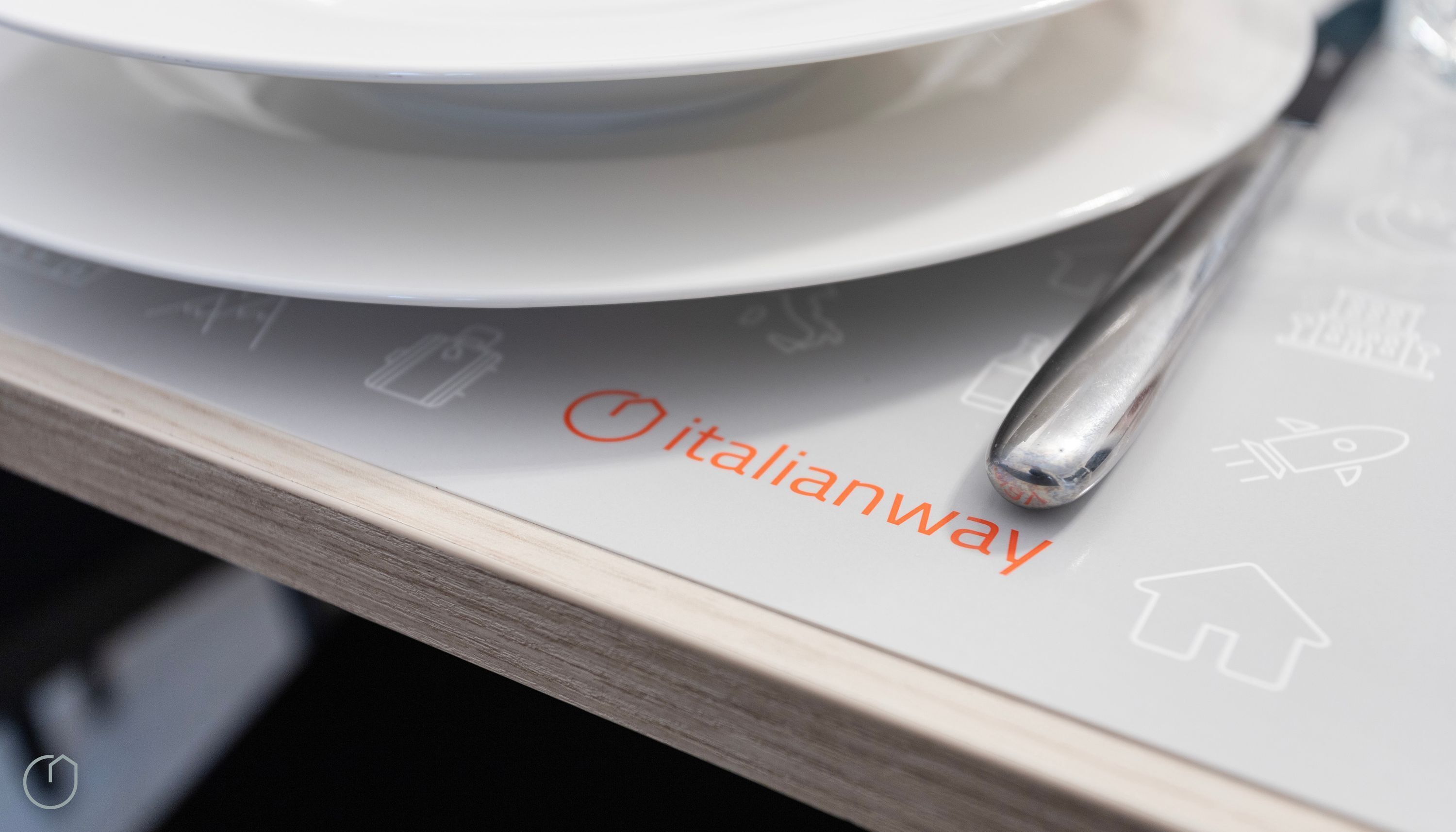 A table with a spoon and a plate, and the text "italianway" on a placemat.