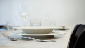 A table set with a white plate, a glass, and a fork. - Italianway - Martinetti 19 (Milan)