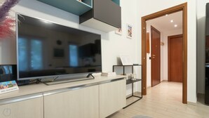 A modern kitchen with a large flat-screen TV, a coffee machine, and a "No Smoking" sign. - Italianway - Martinetti 19 (Milan)