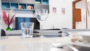 Una mesa de comedor con un vaso de agua, una copa de vino, un tenedor y una servilleta.