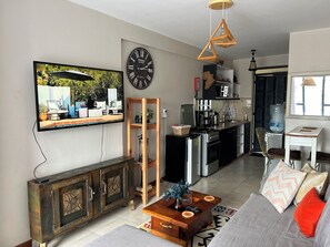 Relax in this stylish living space with a flat-screen TV, wooden cabinet, and comfortable seating area.