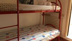 A bunk bed with a polka dot mattress and a patterned pillow.