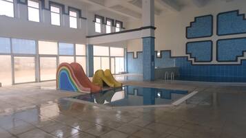 Swimmers can enjoy a refreshing dip in the pool surrounded by a geometric pattern and large windows.