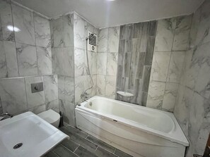 A modern bathroom with a bathtub, a sink, and a toilet. - TERMALYA TERMAL HOTEL (Kozakli)