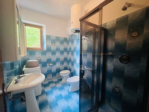 Un baño con lavamanos, inodoro y ducha.