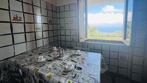 A kitchen with a tiled backsplash, a table set with dishes, and a window with a view of the outdoors.