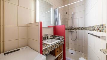 A compact bathroom with a shower, a toilet, and a sink.