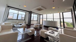 A modern hotel room with large windows, white furniture, and pendant lighting. - Ananya Dorms (Hospet)