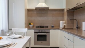 A modern kitchen with a gas stove, oven, and a coffee maker. - Lux apartment with view on Svisloch (Minsk)