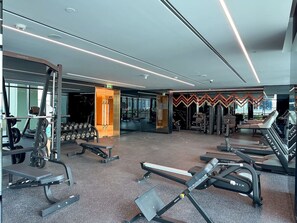 Ein modernes Fitnessstudio mit Laufbändern, Kraftgeräten und Kurzhanteln.