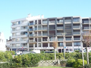 A multi-story residential building with balconies, a parking area, and a street in front. - Cozy Alcove Studio by the Sea in Sables-d'Olonne (Les Sables-d'Olonne)