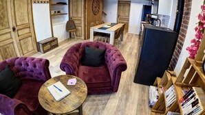 Un salón acogedor con dos sillones cómodos, una mesa de centro de madera y una estantería.
