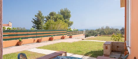 A patio with a table, two chairs, and two glasses of orange juice.