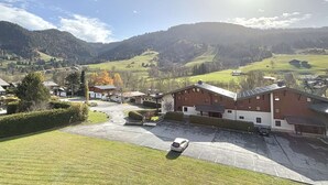A rural setting with a large building that appears to be a farmhouse or barn, surrounded by green fields and mountains in the background. - Alcove studio for 3 with terrace near slopes and parking in Praz-sur-Arly (Praz-sur-Arly)