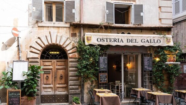 A restaurant named "Osteria del Gallo" with outdoor seating and a stone archway entrance. - Navona "The Corner"  (Roma)