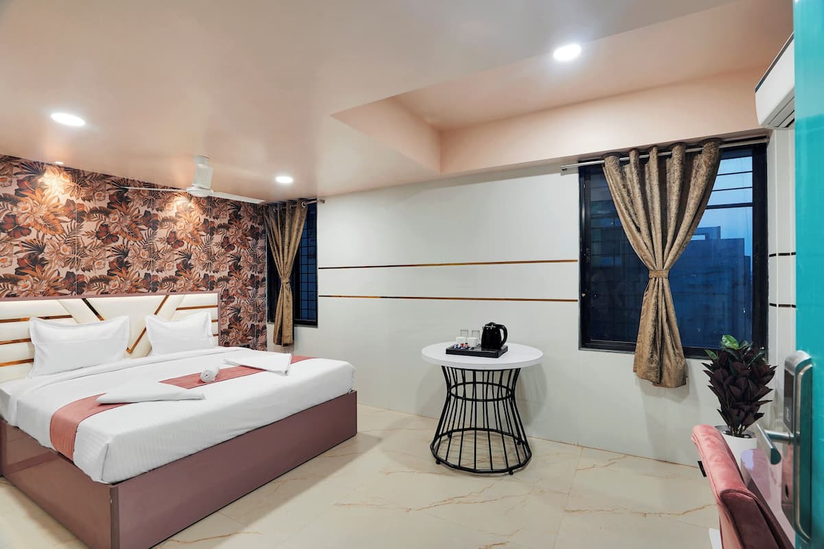 A modern bedroom with a bed, a small round table, and a window with curtains.