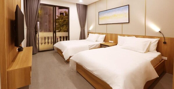 A hotel room with two beds, a TV, a painting, and a sliding glass door to the outside. - Elysees Hotel (Sam Son)