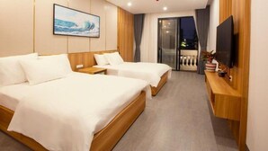 A hotel room with two beds, a TV, and a balcony with a view. - Elysees Hotel (Sam Son)