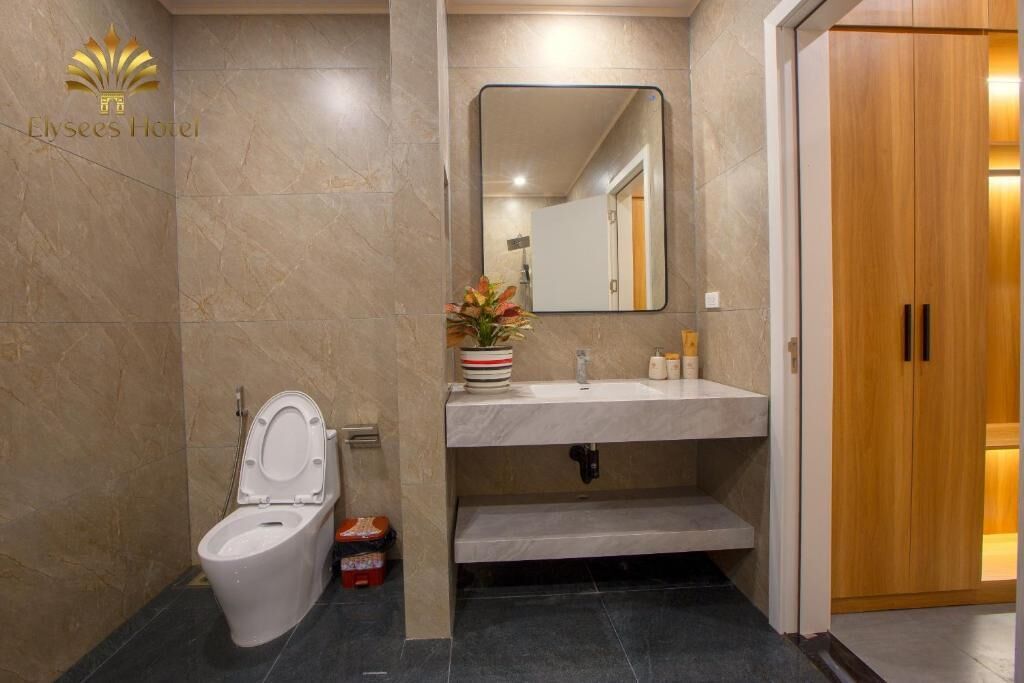 Un baño moderno con inodoro, lavamanos y espejo.